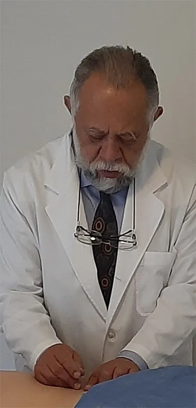 Dr. Wilfrido Reyes aplicando acupuntura a un paciente